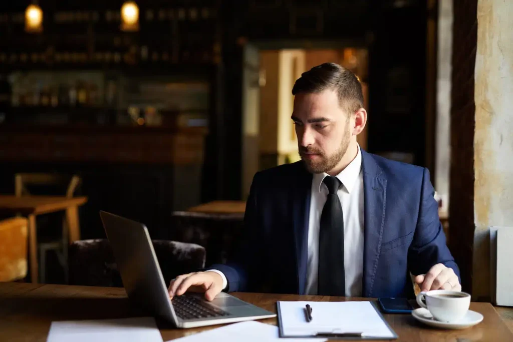 busy man using laptop in cafe PX5GAKJ.jpg